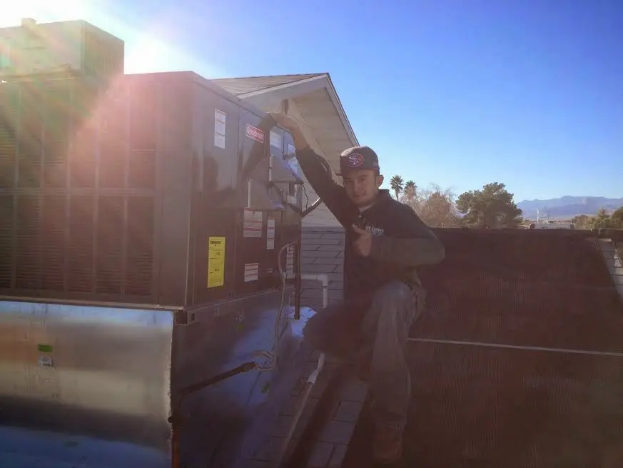 HVAC technician performing Heat Pump Repair on a rooftop unit in Bee Cave